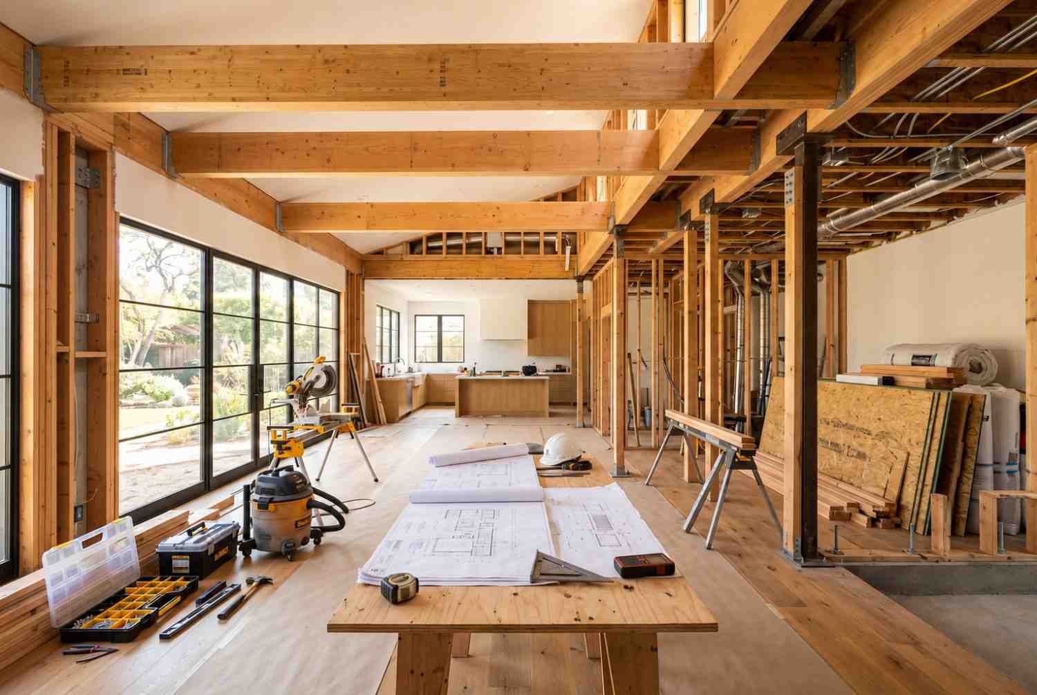 Home renovation with exposed framing, tools, and construction plans.