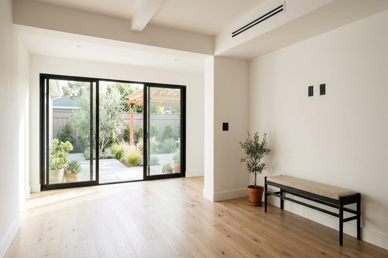 Bright home extension with sliding glass doors opening to a backyard patio.